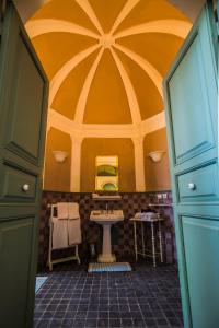 La salle de bains est pourvue d'un lavabo et d'un grand plafond. dans l'établissement Hotel L'Iglesia, à El Jadida