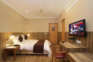 a hotel room with a bed and a flat screen tv at Empire International Church Street in Bangalore +9 photos