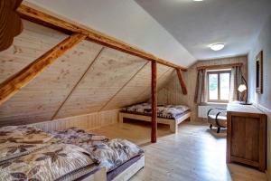 ヴォラリにあるŠumavská Chataのベッドルーム(ベッド2台付)が備わる屋根裏部屋です。