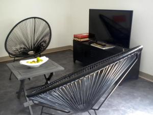 サン・マロにあるLa Cerisaieのリビングルーム(椅子、テーブル、テレビ付)
