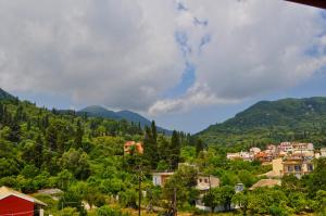 a village in the mountains with houses and trees at Eros Beach Hotel in Benitses