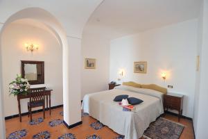 a bedroom with a bed and a table and a mirror at Hotel Belvedere in Conca dei Marini