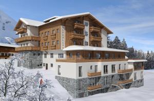 ein großes Gebäude im Schnee mit schneebedeckten Bäumen in der Unterkunft Hotel Alpenland in Obertauern