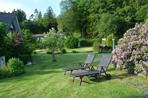 dos bancos y una mesa de picnic en un patio con flores en Kleine Stuga en Windfuß