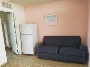 a living room with a couch and a refrigerator at Beach Terrace Motor Inn in Wildwood