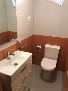 a bathroom with a white toilet and a sink at Casa Leo in Cee