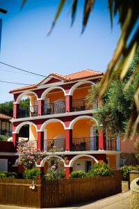 un edificio rosso con balconi e fiori di fronte di Tsiolis Studios & Apartments a Tsilivi