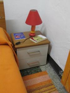 a bedside table with a lamp on a night stand at Guest House Erika in La Spezia