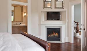 a living room with a fireplace and a tv at Inns of Mendocino in Mendocino