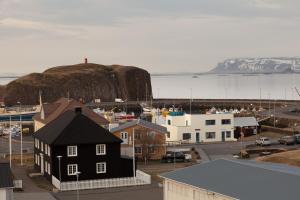 a small town with a black house and a body of water at Sjávarborg in Stykkishólmur