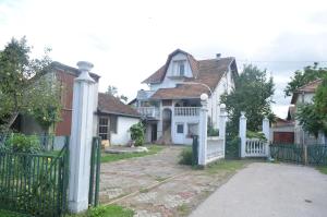 a white house with a gate and a fence at Prenociste Orhideja in Odžak