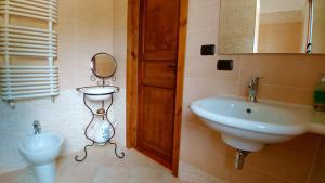 a bathroom with a sink and a mirror and a toilet at Casale del Sole in Cepagatti