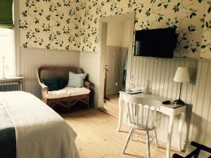 a bedroom with a bed and a desk and a chair at Villamilsten B&B in Lidköping