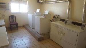 a kitchen with refrigerators and a chair in a room at Split Mountain Motel in Vernal