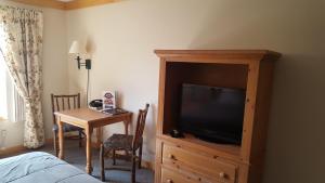 een hotelkamer met een bed, een televisie en een tafel bij Flat Creek Lodge in Hayward