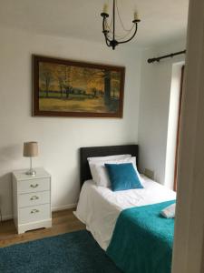 um quarto com uma cama e uma fotografia na parede em 4 Bed House next to Basildon Town Centre em Basildon