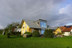 una casa amarilla con techo gris en Ferienwohnung Heldenfingen en Heldenfingen