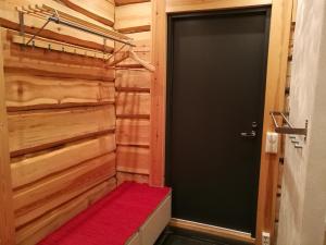 ein Flur mit einer schwarzen Tür und einem roten Teppich in der Unterkunft Syöte Cottage in Syöte