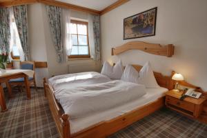 a bedroom with a bed and a table and a window at Appartementhaus Sonne in Ramsau am Dachstein