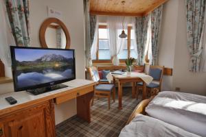 a hotel room with a television and a bedroom at Appartementhaus Sonne in Ramsau am Dachstein