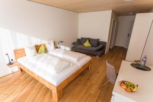 Habitación pequeña con cama y sofá en Gästehaus Gritsch, en Hard