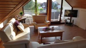 a living room with a couch and chairs and a tv at Haus Lindengarten in Ofterdingen