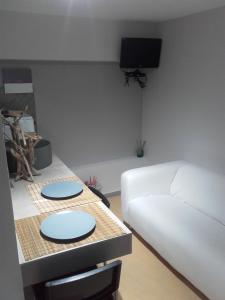 a living room with a white couch and a table at Jennys Apartment in Preveza