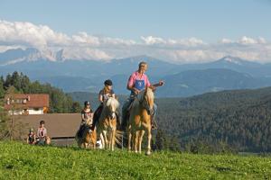 um grupo de pessoas montando cavalos em uma colina em Oberfahrerhof em San Genesio Atesino