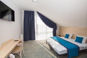 een hotelkamer met een groot bed en een bureau bij Hotel Vela in Tczew