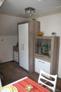 a kitchen with a large white cabinet and a table at Ferienwohnung Baude in Bad Harzburg