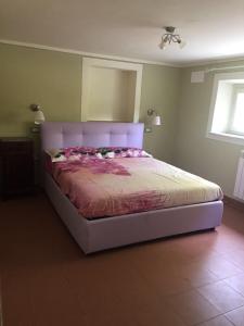 een slaapkamer met een groot bed met een paars hoofdeinde bij Villa Grespola in Lucca
