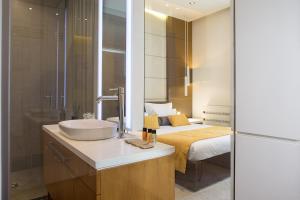 La salle de bains est pourvue d'un lavabo et d'un lit. dans l'établissement Dominic Smart & Luxury Suites - Terazije, à Belgrade