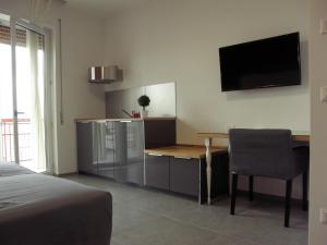 een slaapkamer met een tafel en een televisie aan de muur bij B&B Via Roma 15 in Acquaviva delle Fonti