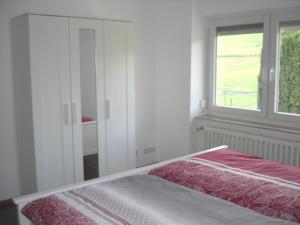 a bed in a white room with a window at Ferienwohnung am Grasweg in Höxter