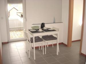 una mesa blanca y sillas con un hervidor de agua. en Ferienwohnung am Grasweg, en Höxter
