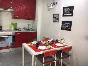 ロス・クリスティアーノスにあるSea View Apartment Los Cristianosのキッチン(白いテーブル、赤いキャビネット付)