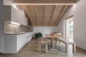 uma cozinha com uma mesa de madeira e um banco de madeira em Ciasa de Lenz em San Cassiano
