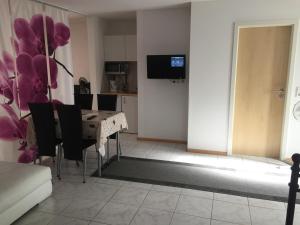 a dining room with a table and chairs and a television at A & J Ferienwohnung Hirsch in Rust