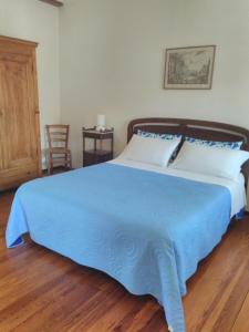 ein Schlafzimmer mit einem großen Bett mit einer blauen Decke in der Unterkunft Ai Cappuccini in Racconigi