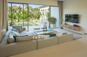 a living room with a couch and a large window at Villa Desi in Bang Tao Beach