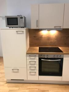 una cucina con forno a microonde e piano cottura di City Pearl for Business and Holiday a Norimberga