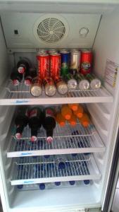 a refrigerator filled with drinks and cans of soda at Liang House and Hostel in Ubud