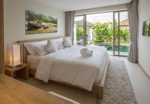 a bedroom with a large bed and a large window at Villa Desi in Bang Tao Beach