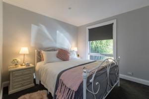 a bedroom with a bed and a window at QUPI HOUSE formerly Rex's Yarra Valley House in Healesville
