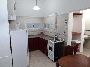 a small kitchen with a stove and a refrigerator at Cabaña La Martina in Chilecito