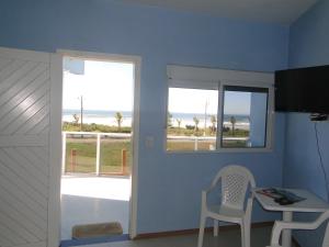 Habitación con escritorio, mesa y ventana. en Pousada Praia da Villa en Imbituba