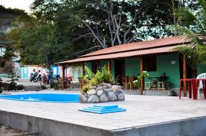 un complexe avec une piscine et une maison dans l'établissement Pousada Villa Bella, à Palmeiras