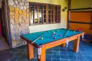 a pool table with balls on it in a room at Pousada Lagomar em Maricá in Maricá