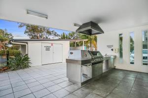 an outdoor kitchen with a stove and a grill at Akama Resort in Hervey Bay