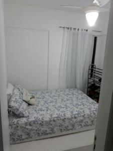 a bedroom with a bed with a blue and white comforter at Apartamento 2 Quartos vista mar in Salvador
